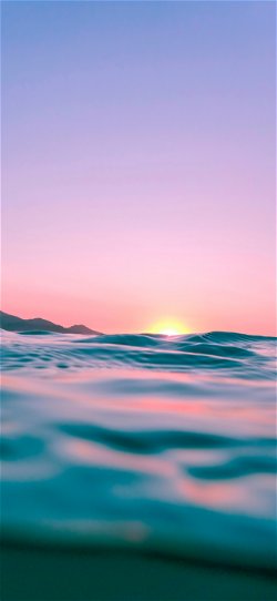 خلفية  غروب الشمس فوق أمواج البحر اللامعة  للايفون