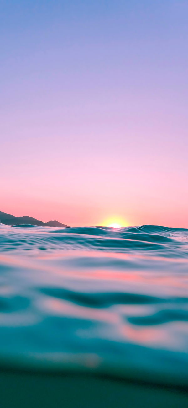 خلفية غروب الشمس فوق أمواج البحر اللامعة للجوال
