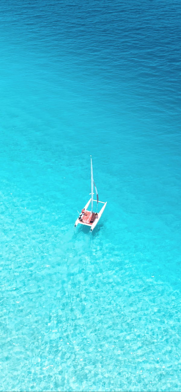 خلفية قارب صغير في مياه البحر الفيروزية الصافية للجوال