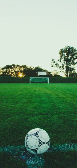 خلفية  كرة قدم فوق العشب الاخضر بمواجهة المرمى  للجوال