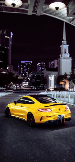 خلفية  سيارة مرسيدس رياضية صفراء في المدينة المظلمة  للجوال