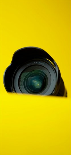 خلفية  عدسة كاميرا احترافية على سطح اصفر  للجوال