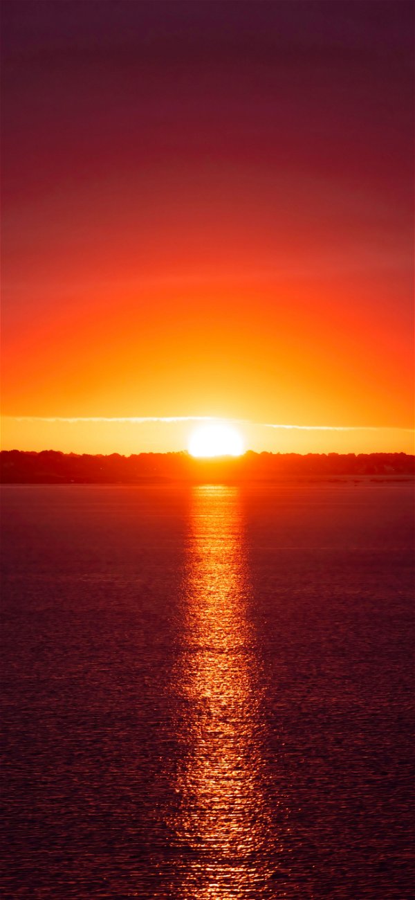 خلفية غروب الشمس فوق مياه البحر الهادئة الرقيقة للجوال