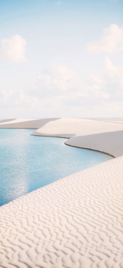 خلفية  التقاء رمال الصحراء البيضاء مع مياه البحر النقية  للجوال
